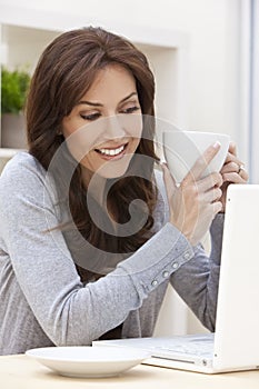 Una mujer computadora portátil computadora bebiendo té o café 