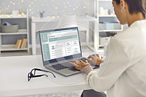 Woman using laptop computer, managing her bank account and transferring money online photo