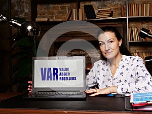 Woman using laptop computer with  VAR VALUE ADDED RESELLERS icon on screen background, success in business concept