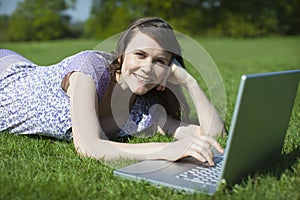Woman Using Laptop On Grass