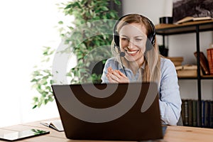 Woman using laptop and headset