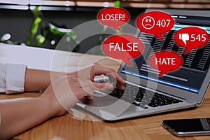 Woman using laptop and icons with offensive messages, closeup. Cyber bulling concept