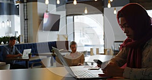 Woman using laptop and mobile phone in cafe 4k