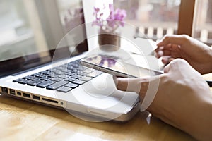 Woman using laptop and mobile phone to online shopping and pay by credit card. photo