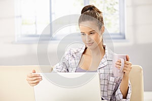 Woman using laptop in morning