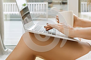 Woman is using laptop pc and drinking coffee