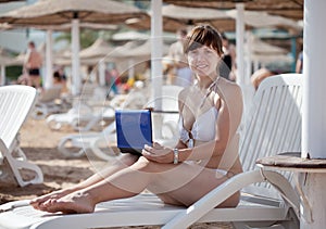 Woman using laptop at resort beach