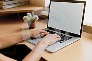 Woman using laptop, searching web, browsing information, having workplace at home.