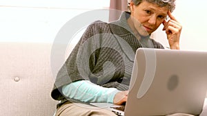 Woman using laptop while sitting