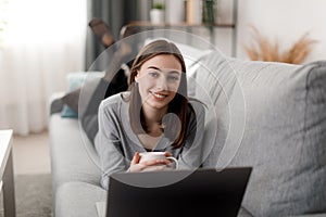 Woman using laptop on sofa