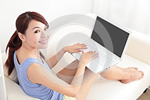 Woman using laptop on sofa