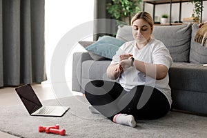 Woman using laptop and sport tracker