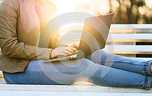 Woman using laptop in sunset outdoors
