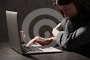 Woman using laptop at table against. Loneliness concept photo