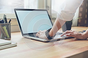 Woman using laptop on table in office room, for graphics display montage.