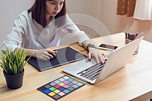 Woman using laptop on table in office room, for graphics display montage.