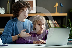 Woman using laptop to study with child