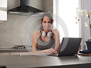 woman using laptop to watch online fitness webinar at home