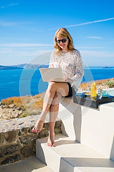 Woman using laptop while on vacation in Mediterranean