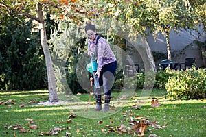 Woman using leaf blower in garden