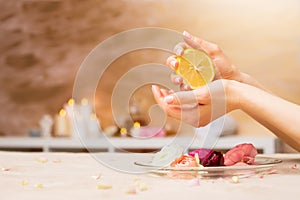 Woman using lemon in manicure procedure