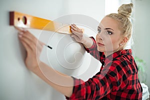 Woman using leveling tool at home