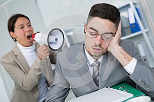 Woman using loudhailer to wake businessman photo