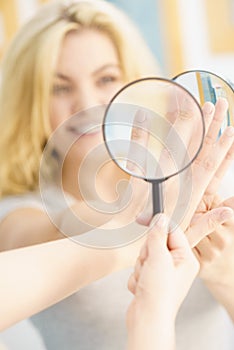 Woman using magnifer on nails