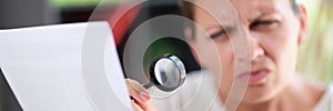 Woman using magnifying glass to read text on paper, eye diseases and health problem concept.