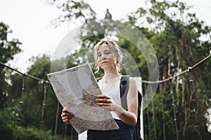 Woman using the map for direction in the forest