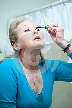 Woman using mascara to make up her eyes