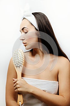 woman using massage brush for peeling and exfoliation