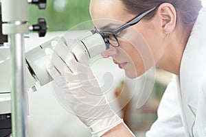 Woman using microscope in laboratory