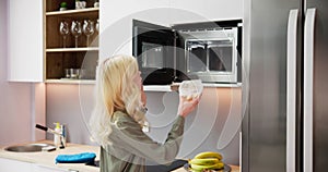Woman Using Microwave Oven For Heating Food photo