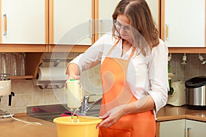 Woman using mixer in kitchen