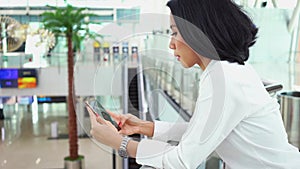 Woman using mobile phone in airport terminal