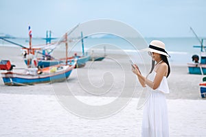 Woman using mobile phone on beach