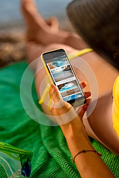 Woman using mobile phone on the beach
