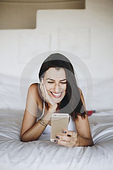 Woman using a mobile phone in bed