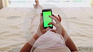 Woman using mobile phone on bed alpha channel