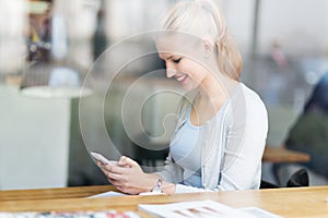 Woman using mobile phone at cafe