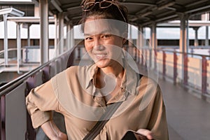 Woman is using mobile phone on the city bridge in Bangkok.