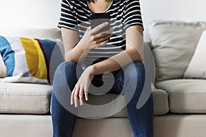 Woman using mobile phone on the couch