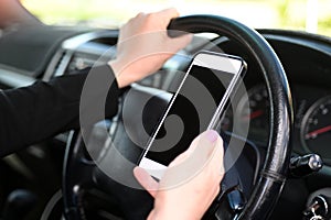 Woman using mobile phone while driving a vehicle