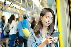 Woman using mobile phone inside train compartment