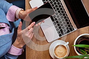 Woman using mobile phone and laptop computer