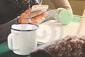 Woman using mobile phone and laptop on workspace desk. Technology lifestyle concept