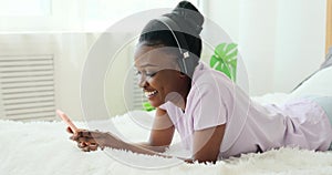 Woman using mobile phone while listening music on headphones
