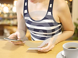 Woman using mobile phone shopping online with credit card