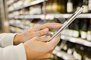 Woman using mobile phone while shopping in supermarket